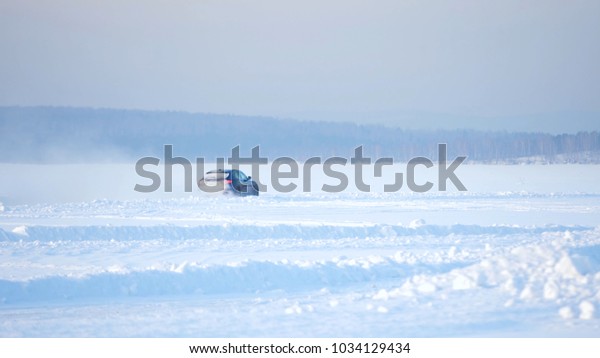 DRIVING IN THE SNOW. Winter\
car tracks on snowy beach. Driving a race car on a snowy road.\
Track Winter car racing with sun reflection. Race on the track in\
the winter