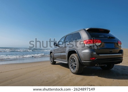 Driving an SUV down a sandy driveway and parking on the beach while looking at the blue sky and sea
青い空と海を眺めながら、SUVで砂浜のドライブウェイを走行し、砂浜に駐車する