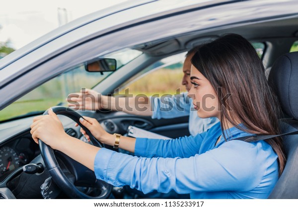 Driving Test, Focused on the road ahead of her.\
Driving Test. Student driver taking driving test. American Woman\
Learning Driver\'s\
Education
