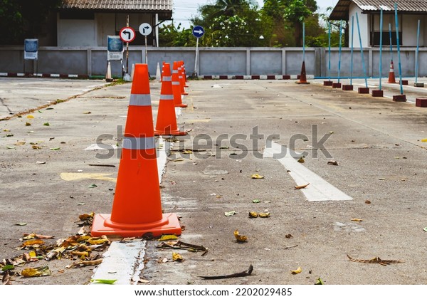 Driving test and training area with simulate test\
for driving license. Driving school practice traffic area with pole\
signs and orange cones and road signs for safety on concrete road.\
Selective focus