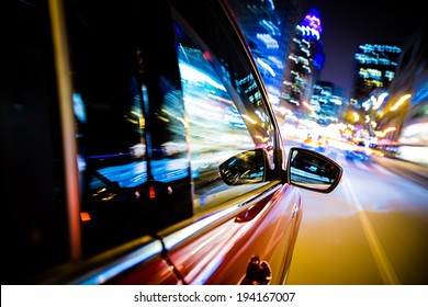 Driving Through City Lights. Car Side and Mirror View. Night Drive Concept