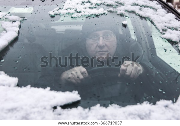 Driving through a foggy\
windshield Driver looking through a foggy window, shallow focus,\
focus on hands