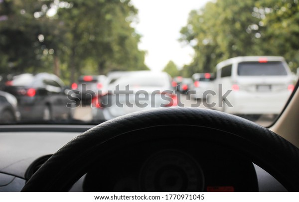 driving in traffic jam on holiday in\
Thailand, point of view first person in car without\
hands