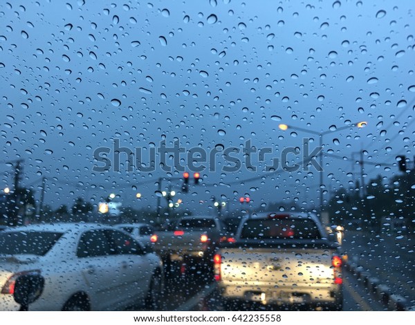 Driving in a Traffic in raining day with rain\
drops on the window