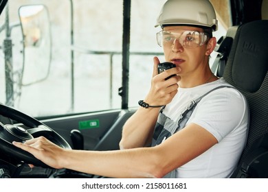 Driving transport. Worker in professional uniform is on the borrow pit at daytime.
