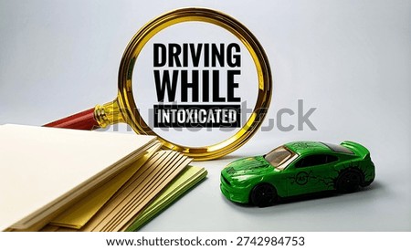 Driving While Intoxicated concept seen through magnifying glass with car and document representing impaired driving offense. 