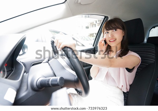 Driving woman using\
smartphone