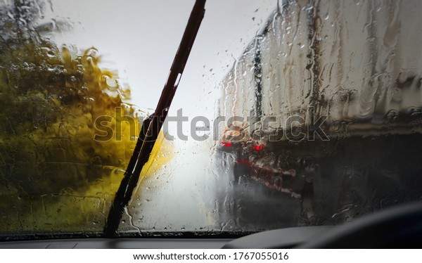 Driving,bad weather conditions on the road during rain\
storm,view through the wind shield with selective focus and color\
toned. 