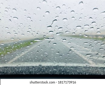 Drizzle On The Windsheild, Inside Car When Rainning, Road View Through Car Window With Rain Drops.