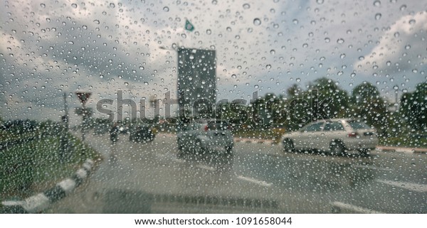Drizzle on the windshield, Inside car when
rainning, Road view through car window with rain drops. View
through car window blurry with heavy
rain.