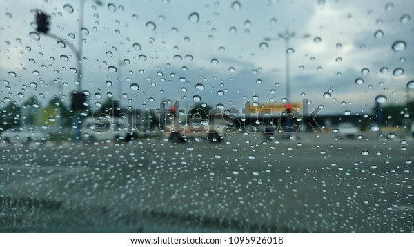 Drizzle on the windshield, Inside
car when rainning, Road view through car window with rain
drops.