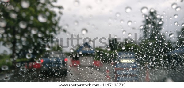 Drizzle on the windshield, Inside
car when rainning, Road view through car window with rain
drops.