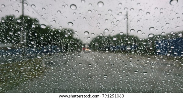 Drizzle on the windshield, Inside\
car when rainning, Road view through car window with rain\
drops.