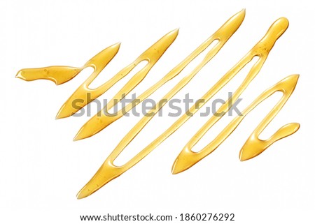 Drizzled wavy line of healthy fresh golden organic honey isolated on white with copyspace viewed from above