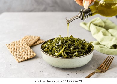 Drizzling Olive Oil over Seaweed Salad