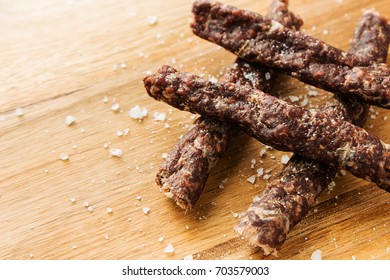 Droewors (biltong) on a salted wooden board, this is a traditional food snack that can be found in South Africa. This image has selective focusing. 