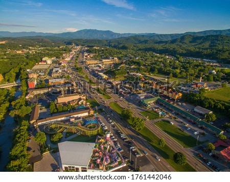 Drone, aerial, angled view of shadows cast from setting sun on main strip in Pigeon Forge, Tennessee