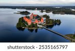 Drone aerial footage of Trakai Castle in the evening. Lakes, forests and islands around. Aerial drone shot of red brick medieval castle on island in Trakai, Vilnius region, Lithuania. 