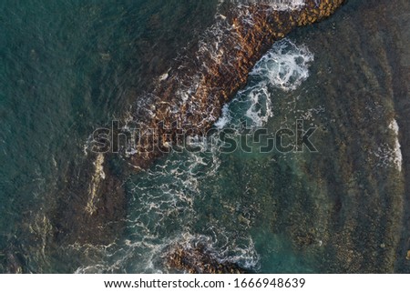 Similar – Aerial Drone View Of Dramatic Ocean Waves Crushing On Rocky Landscape