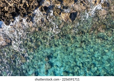 Drone aerial of rocky sea coast with transparent turquoise water. Seascape top view, Protaras Cyprus