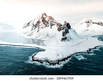 Drone aerial shot of Eystrahorn, mountains in Iceland during winter with lot of light nad snow. Beautiful view on coast and waves.  - Shutterstock ID 1899467959