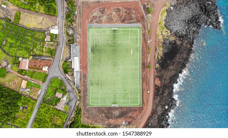 Drone aerial of soccer field by ocean