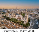 The drone aerial view of Bordeaux Cathedral and Pey Berland Tower at sunrise, Bordeaux, France.