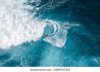 Drone aerial view of people surfing on the sea in Bali, Indonesia