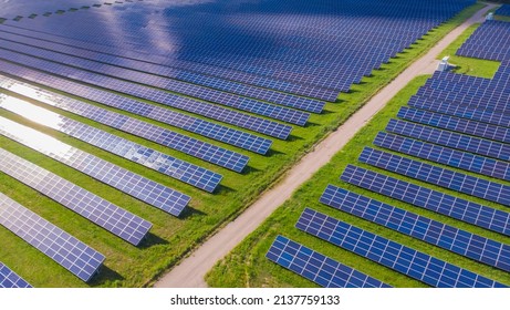 Drone Aerial View Of A Photovoltaic Solar System. Metallic Blue Solar Panels, Renewable And Sustainable Energy Technology. Alternative Energy, Go Green Background.