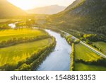 Drone aerial view of Rauma river and the mountain peaks in backgroud. Summer sunset in Norway