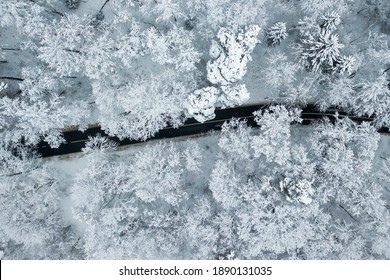 Drone Aerial View Of Road In The Snowy Forest. Vilnius County, Lithuania