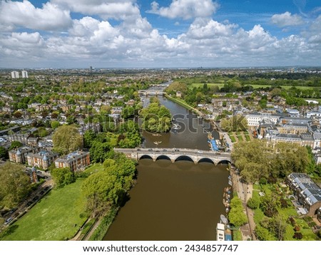 The drone aerial view of Thames River runs through Richmond town centre on the east bank with its neighbouring district of East Twickenham to the west, London, UK.