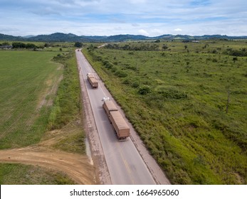 Drone Aerial View Of Trucks Transporting Soy Along The BR 163 Road And Cattle Pasture Farm Near Novo Progresso City In The Amazon. Rainforest Area And Deforestation In The Background. Para, Brazil.