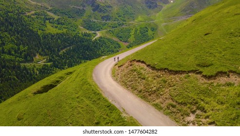 Drone Aerial View Of Two Un Recognisable Cyclists Cycling On Mountain Roads In The French Pyrenees 