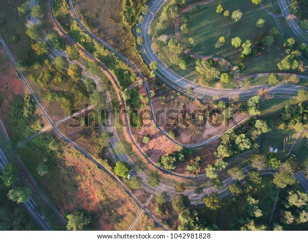 Drone Aerial view of Winding road up on a hill\
surrounded by trees