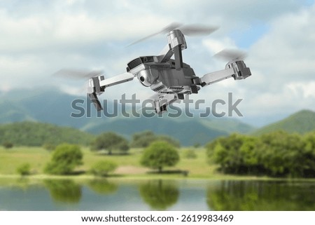 Drone with camera flying over river. Unmanned aerial vehicle for surveillance