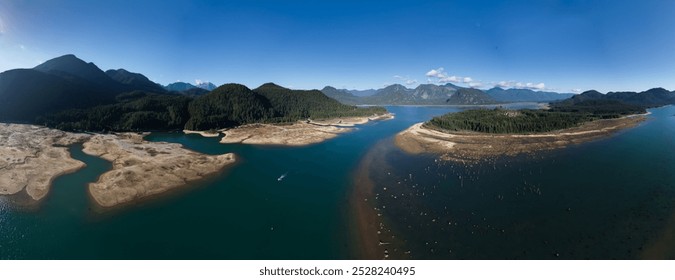 Drone captures breathtaking panoramic scenery of BC, Canada, showcasing serene lakes, dense forests, and majestic mountains, all beneath vibrant blue skies. - Powered by Shutterstock