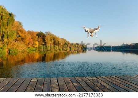 Drone copter with digital camera, blur river on background