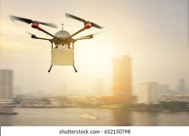 Drone Delivery Flying Carry Product Paper Box On City Sunset Sky                               