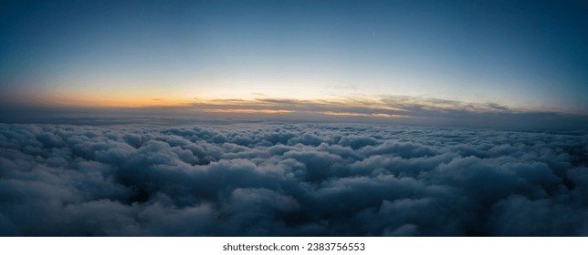 A drone flies over fluffy clouds at sunset. The drone flies through the clouds, creating a sense of wonder and awe