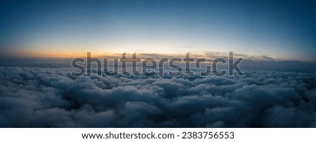 A drone flies over fluffy clouds at sunset. The drone flies through the clouds, creating a sense of wonder and awe