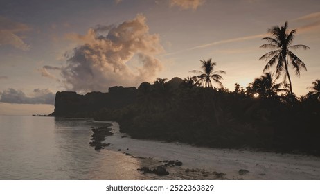 Drone flight over tropical island beach, palm trees silhouette against golden sunset light, dramatic volcanic peaks of Maupiti archipelago in French Polynesia. Beautiful landscape of untouched nature - Powered by Shutterstock