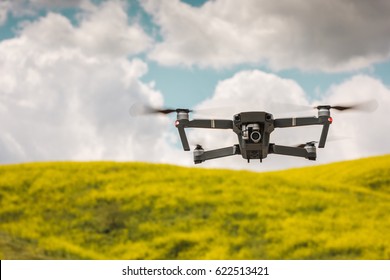 Drone flying during the day in field of flowers