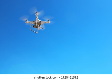 Drone flying in fromt of a blue sky - Shutterstock ID 1920481592