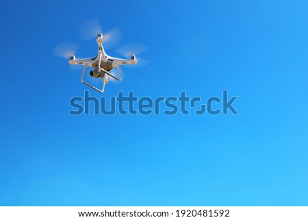 Drone flying in fromt of a blue sky