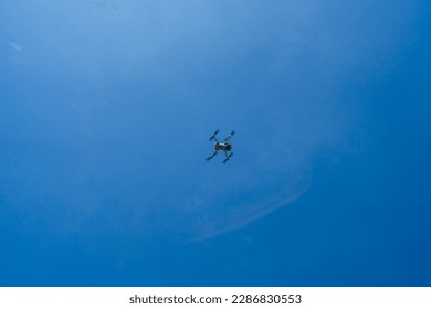 A drone hovering in the air. The sky in the background