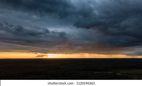 Drone Image. Aerial View Of Rural Area With Houses And Roads Under Heavy And Dark Dramatic Rain Clouds In Summer Day. Night Photo. Latvia