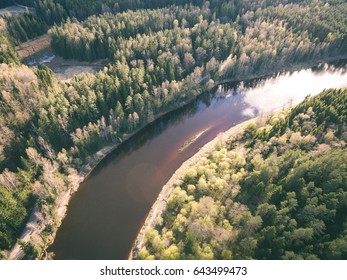 drone image. aerial view of rural area with river and broken cloud shadows on the forests - vintage effect