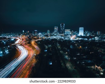 A drone long exposure of a cityscape with vibrant lights coming off the ckyscrapers at night - Shutterstock ID 2229839033