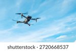 Drone machine with blue sky background for commercial marketing. Drone services for land and environmental assessment, providing reliable aerial insights.